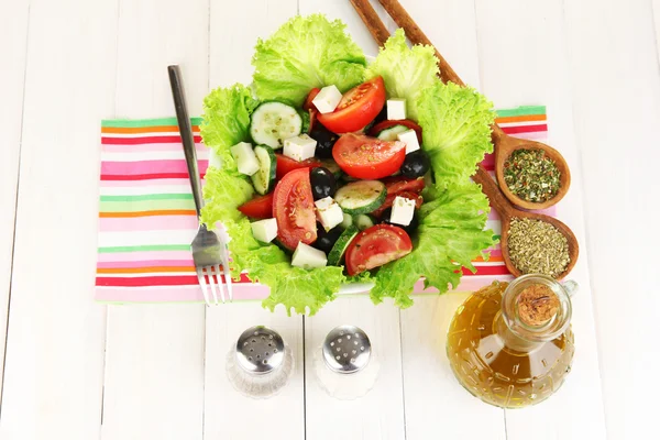 Вкусный греческий салат со специями на белом деревянном фоне — стоковое фото