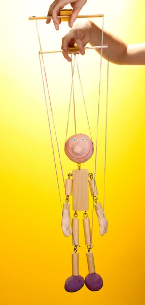 Wooden puppet on yellow background — Stock Photo, Image