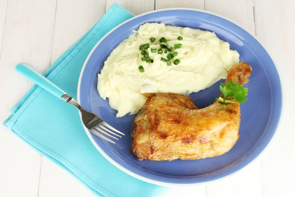 Roasted chicken leg with mashed potato in the plate on white wooden table close-up Royalty Free Stock Photos