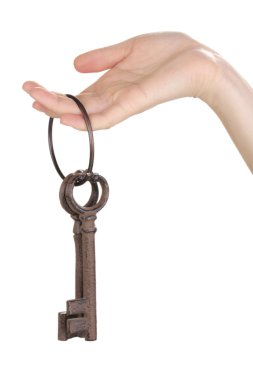 Woman's hand holding a bunch of antique keys on white background clipart