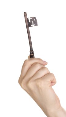 Woman's hand holding an antique key on white background clipart