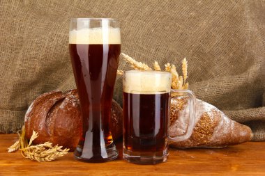 Two glasses of kvass with bread on canvas background close-up clipart