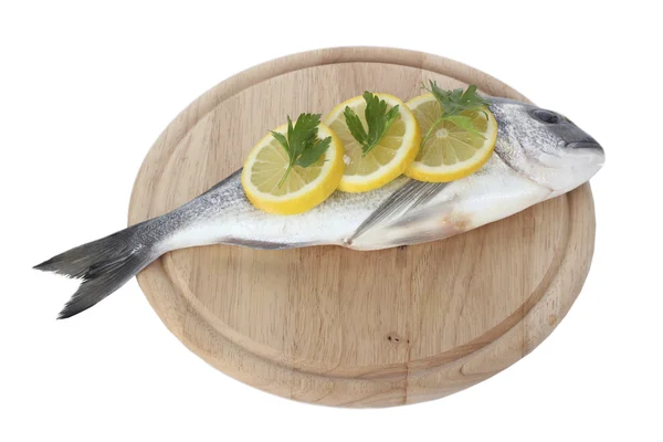 Peixe fresco com limão e salsa em tábua de corte de madeira isolada em branco — Fotografia de Stock