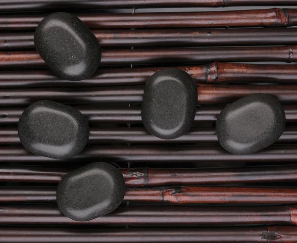 Pedras de spa em esteira de bambu — Fotografia de Stock