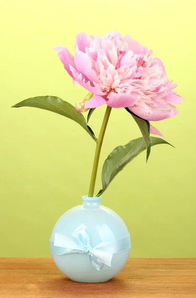 Rosa pion i vas på träbord på grön bakgrund — Stockfoto