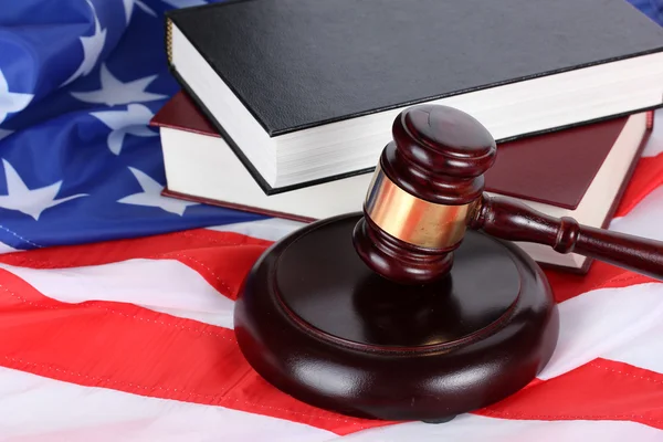 Soudce kladívkem a knihy na pozadí americké vlajky — Stock fotografie
