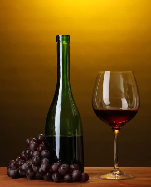 Samenstelling van wijn fles en wijnglas op houten tafel op bruine achtergrond — Stockfoto