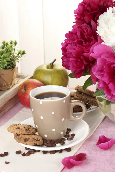 Cup of coffee, cookies, apples and flowers on table in cafe — Stock Photo, Image