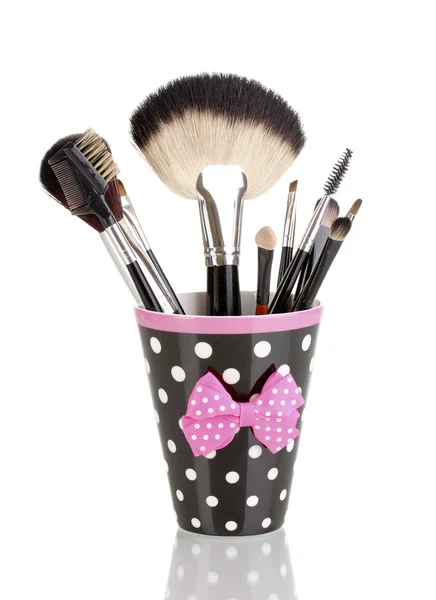 Make up borstels in een polka-zwarte kop geïsoleerd op wit — Stockfoto