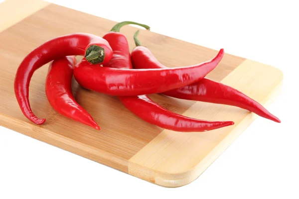 Red hot chili peppers on wooden plank isolated on white — Stock Photo, Image