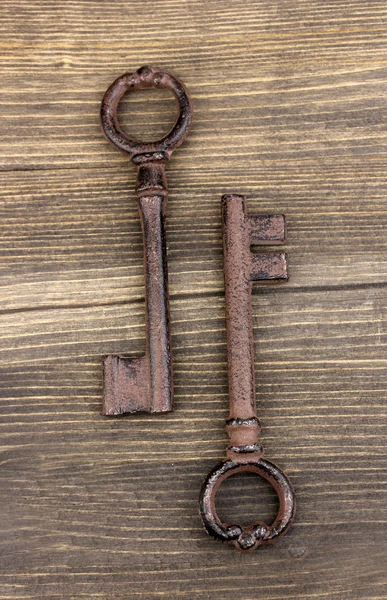 Zwei antike Schlüssel auf Holzgrund — Stockfoto