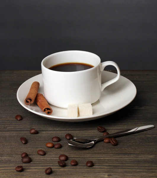 Кофейная чашка на деревянном столе на сером фоне — стоковое фото