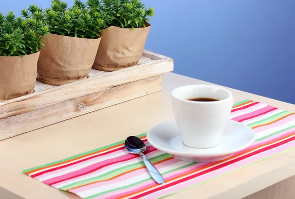 Kaffeetasse auf Tisch im Café auf blauem Hintergrund — Stockfoto