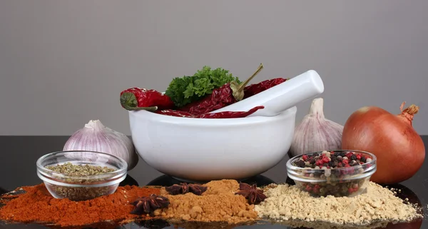 Sammansättningen av vit mortel och stöt med kryddor och grönsaker isolerad på grå bakgrund — Stockfoto
