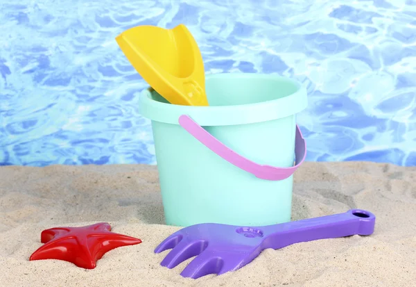 Zabawki dla dzieci plaży na piasku na tle wody — Zdjęcie stockowe