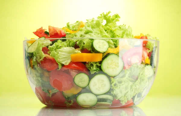 在绿色背景上的透明碗新鲜蔬菜沙拉 — 图库照片