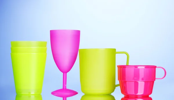 Bright plastic tableware on blue background — Stock Photo, Image