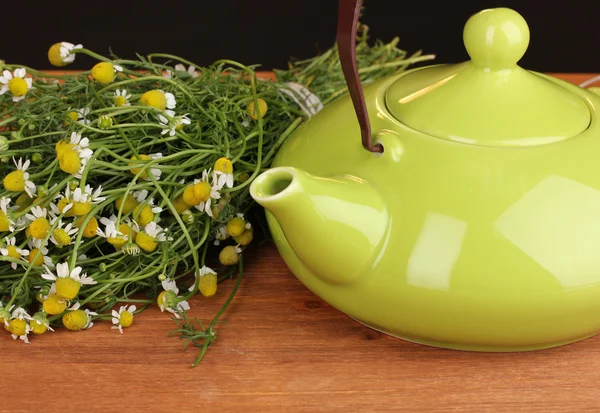 Teapot with chamomile tea on wooden table close-up — Stock Photo, Image