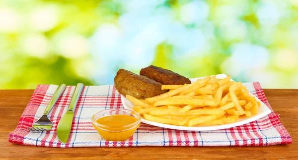 Картофель фри с бургерами на тарелке на зеленом фоне крупным планом — стоковое фото