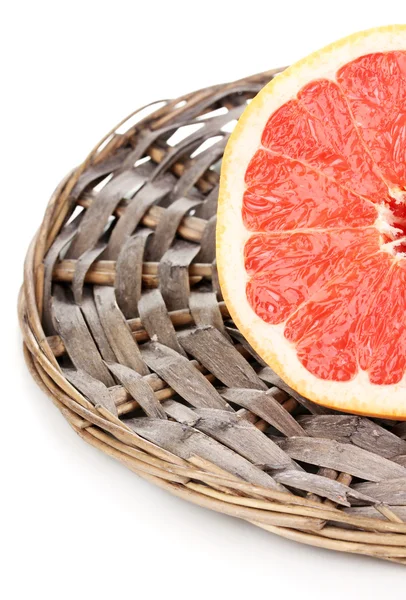 De helft van rijp grapefruit op rieten mat geïsoleerd op wit — Stockfoto