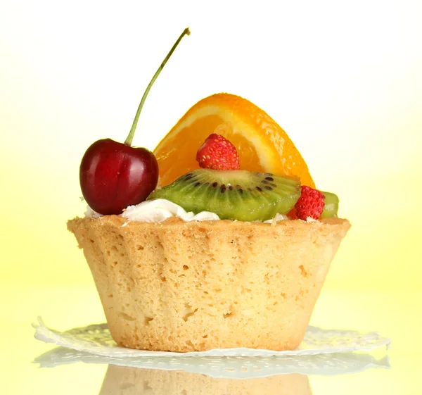 Sweet cake with fruits on yellow background — Stock Photo, Image