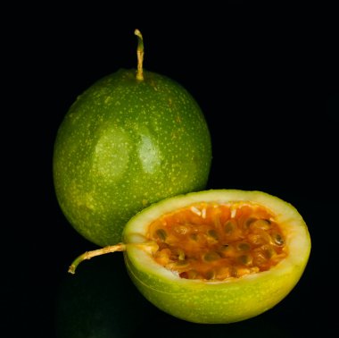 Green passion fruit isolated on black background clipart