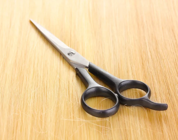 Shiny blond hair and hair cutting shears close-up — Stock Photo, Image