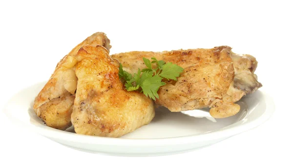 Жареные куриные крылышки и нога с петрушкой в тарелке изолированы на белом — стоковое фото