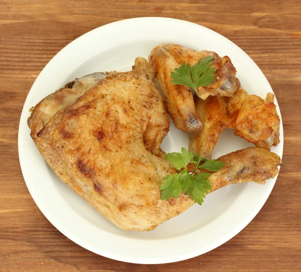 Pečená kuřecí křídla a nohy s petržel v talíř na detail dřevěné pozadí — Stock fotografie