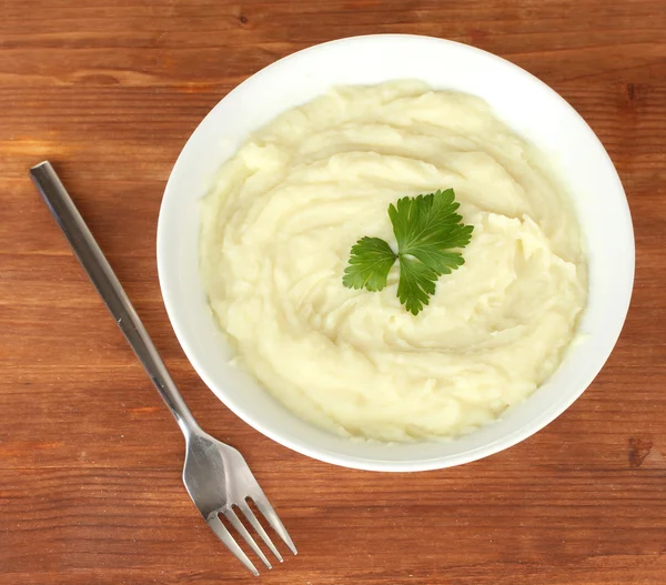 Mashed potato with parsley in the bowl on wooden background close-up — Stock Photo, Image