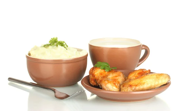 Puré de papa con perejil en el tazón y alitas de pollo asadas en el plato y taza con leche aislada en blanco —  Fotos de Stock