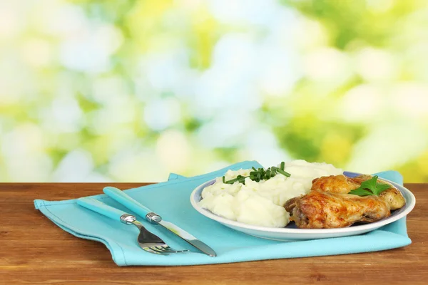 Kavrulmuş Tavuk budu plaka üzerinde parlak arka plan yakın çekim üzerinde ahşap masa patates püresi ile — Stok fotoğraf