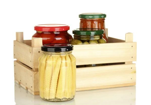 Frascos com legumes enlatados em caixa de madeira isolada em branco — Fotografia de Stock