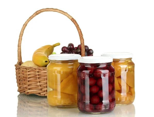 Frascos de fruta enlatada y cesta con fruta aislada en blanco —  Fotos de Stock
