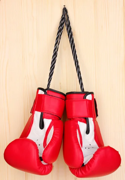 Червоні боксерські рукавички, що висять на дерев'яному фоні — стокове фото