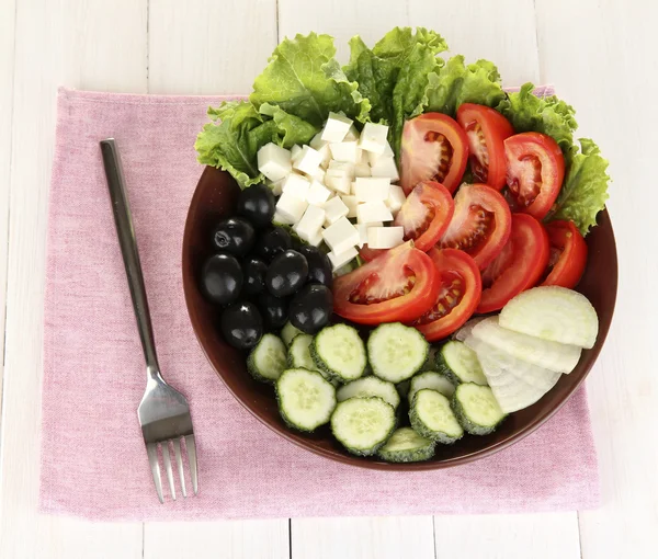 Ízletes görög saláta fehér fa háttér — Stock Fotó