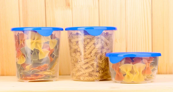 Gefüllte Kunststoffbehälter auf Holzgrund — Stockfoto