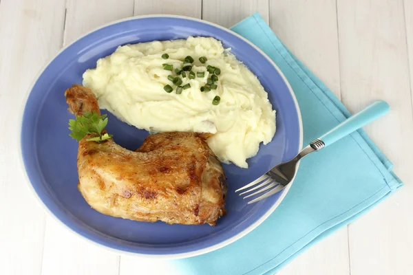 Roasted chicken leg with mashed potato in the plate on white wooden table close-up Royalty Free Stock Photos