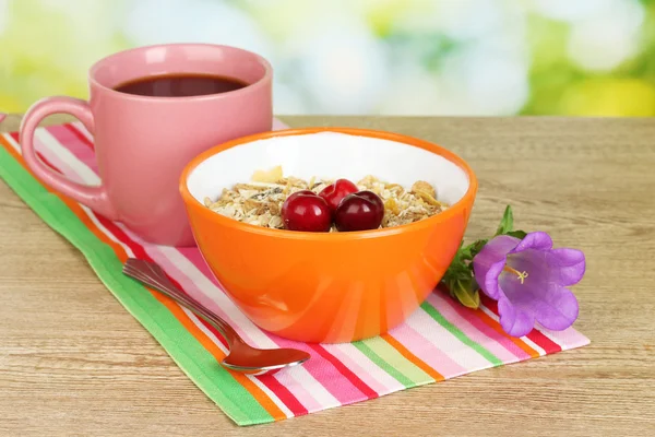 Leckeres Müsli mit Kirschen zum Frühstück auf Holztisch auf grünem Hintergrund — Stockfoto