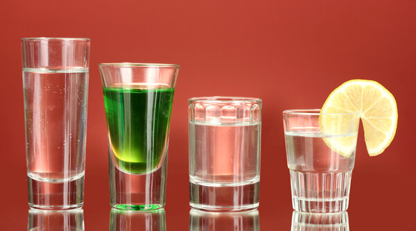 A variety of alcoholic drinks on red background
