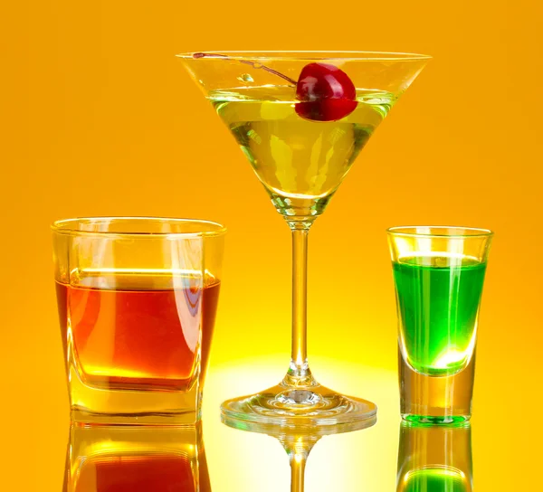 Una variedad de bebidas alcohólicas sobre fondo amarillo —  Fotos de Stock