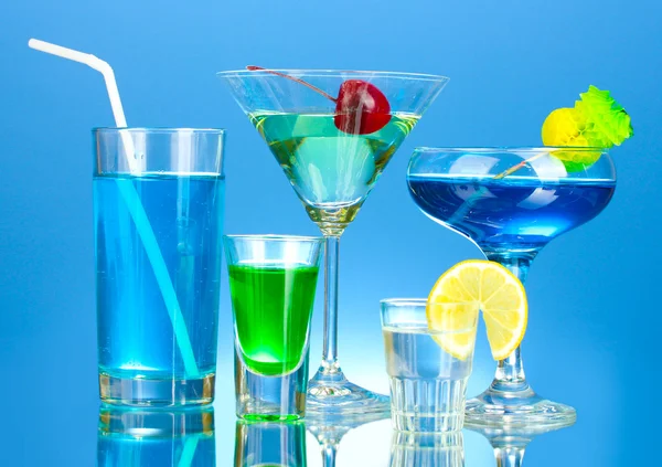 Szeroki wybór napojów alkoholowych na niebieskim tle — Zdjęcie stockowe