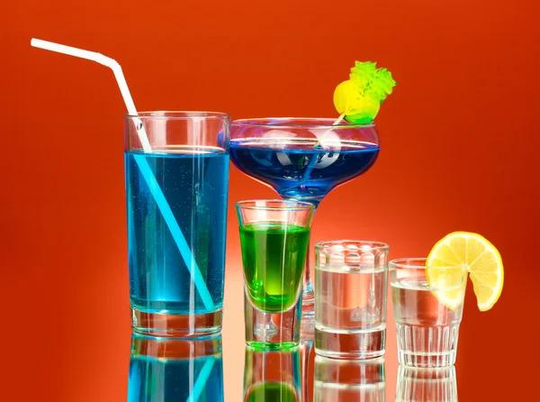 A variety of alcoholic drinks on red background — Stock Photo, Image