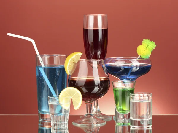 赤い背景の上のアルコール飲料のさまざまな — ストック写真