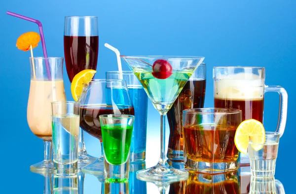 Une variété de boissons alcoolisées sur fond bleu — Photo