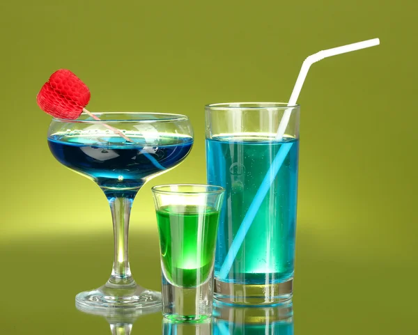 Szeroki wachlarz napojów alkoholowych na zielonym tle — Zdjęcie stockowe
