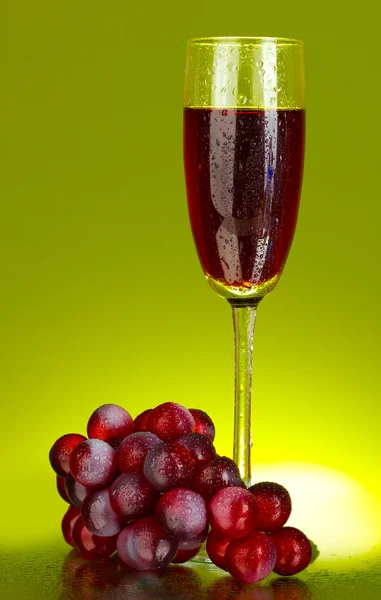 Um copo de vinho e uvas em fundo verde close-up — Fotografia de Stock