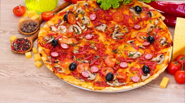 Deliciosa pizza e legumes na mesa de madeira — Fotografia de Stock