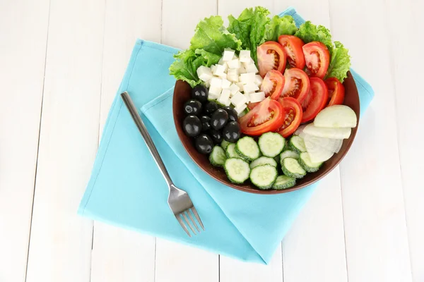 Savoureuse salade grecque sur fond de bois blanc — Photo
