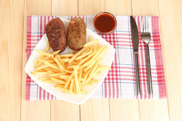 나무 배경 클로즈업에 접시에 햄버거와 감자 튀김 — 스톡 사진